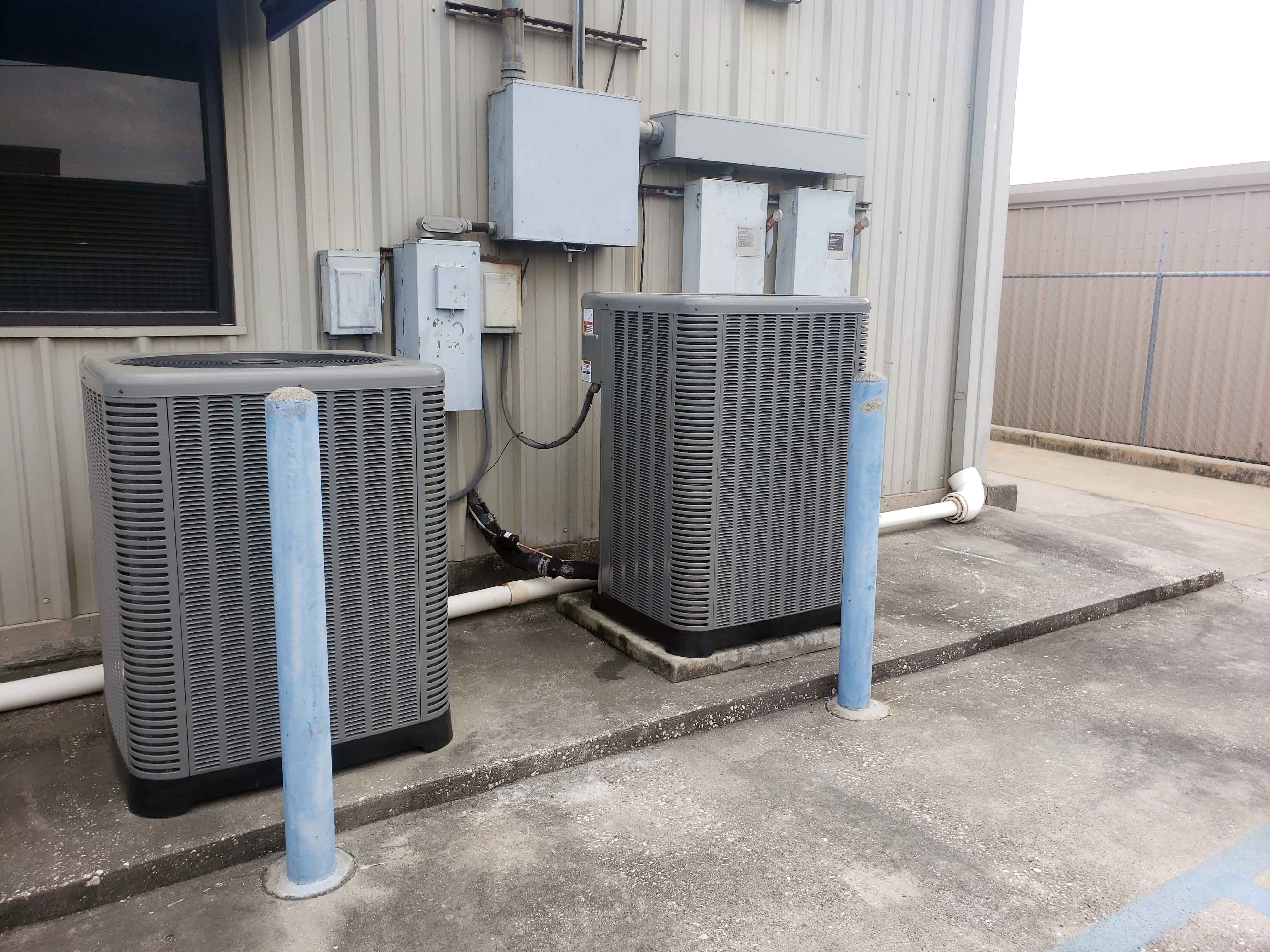 Two recently installed outdoor condensing units at a commercial facility showing professional AC installation work in Houston
