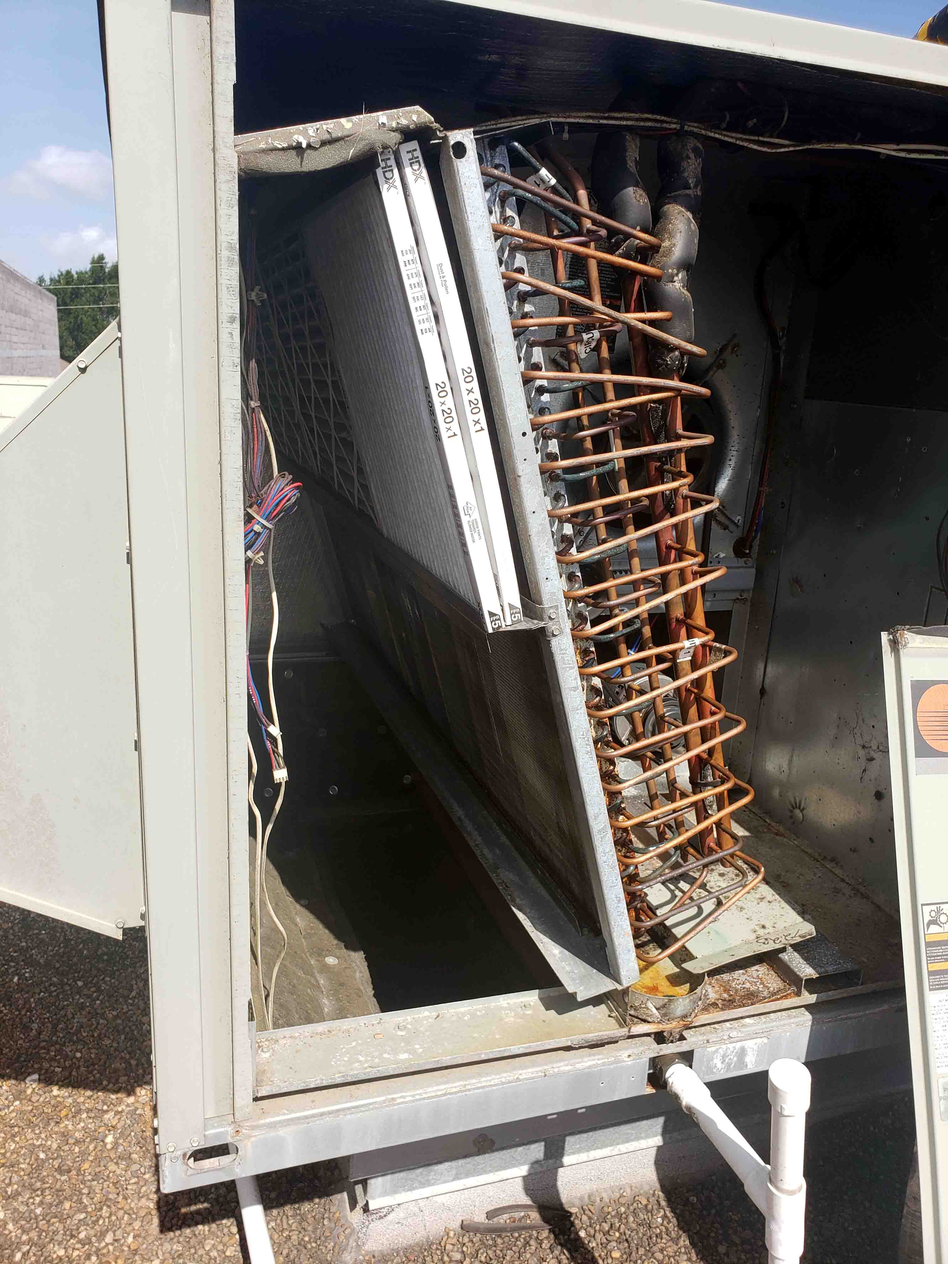 A rooftop packaged AC system having its air filters replaced during preventative maintenance service in Houston