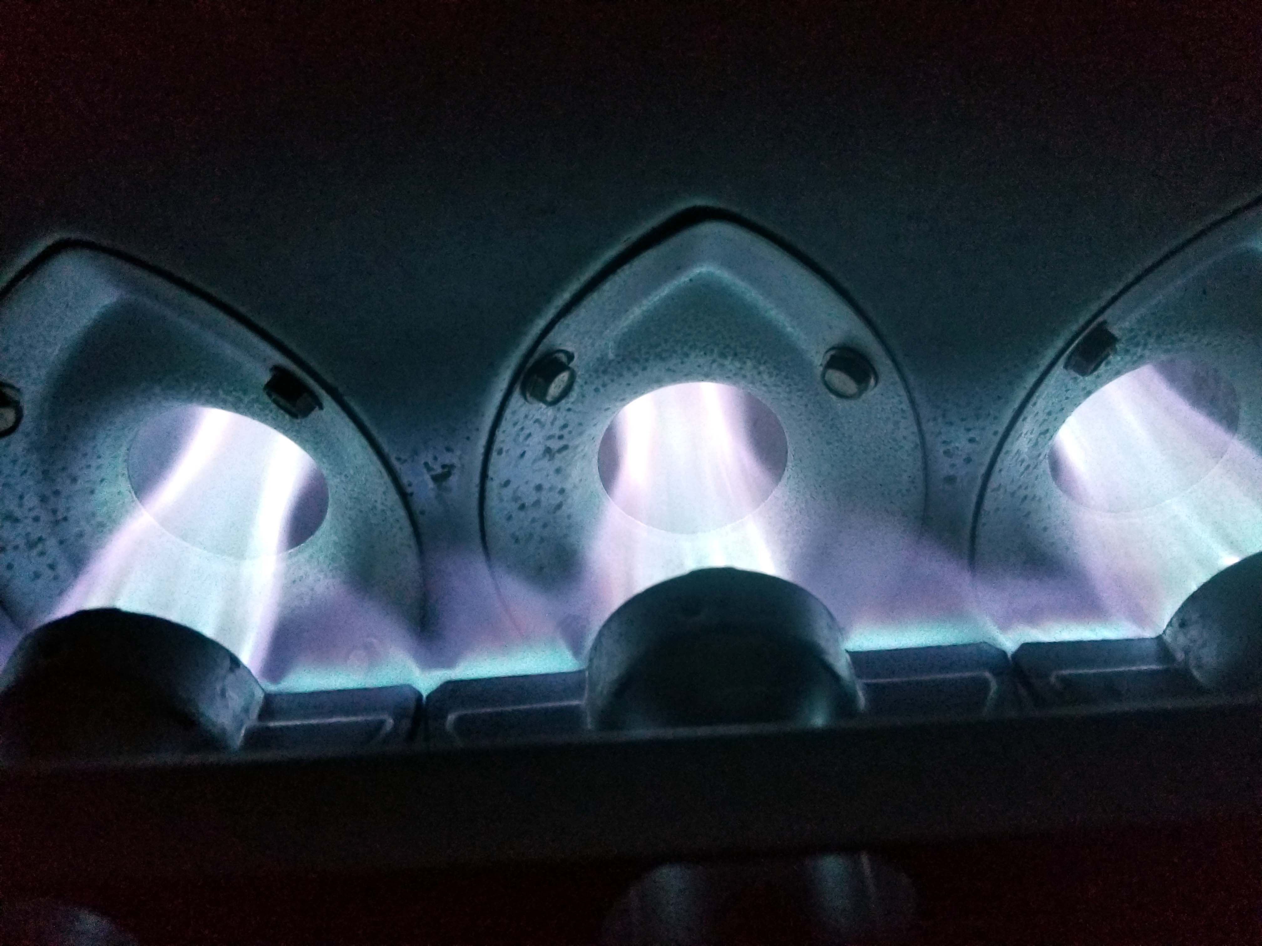 The blue flames of a residential gas furnace burning brightly as the furnace heats a home in Houston